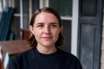 portrait of a white person with a short bob hairstyle, they are smiling while looking off towards the right of the camera