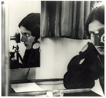 Self portrait of the photographer with several mirror reflecting different sides of her face behind the camera.