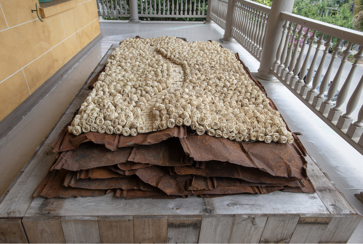 an elevated platform with rusted slats of metal covered in a blanket of white paper flowers