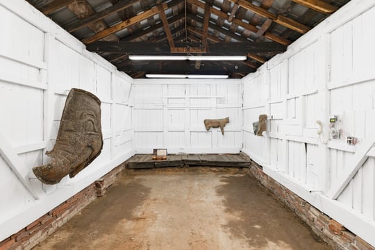 installation view of gallery with white walls and sculpture