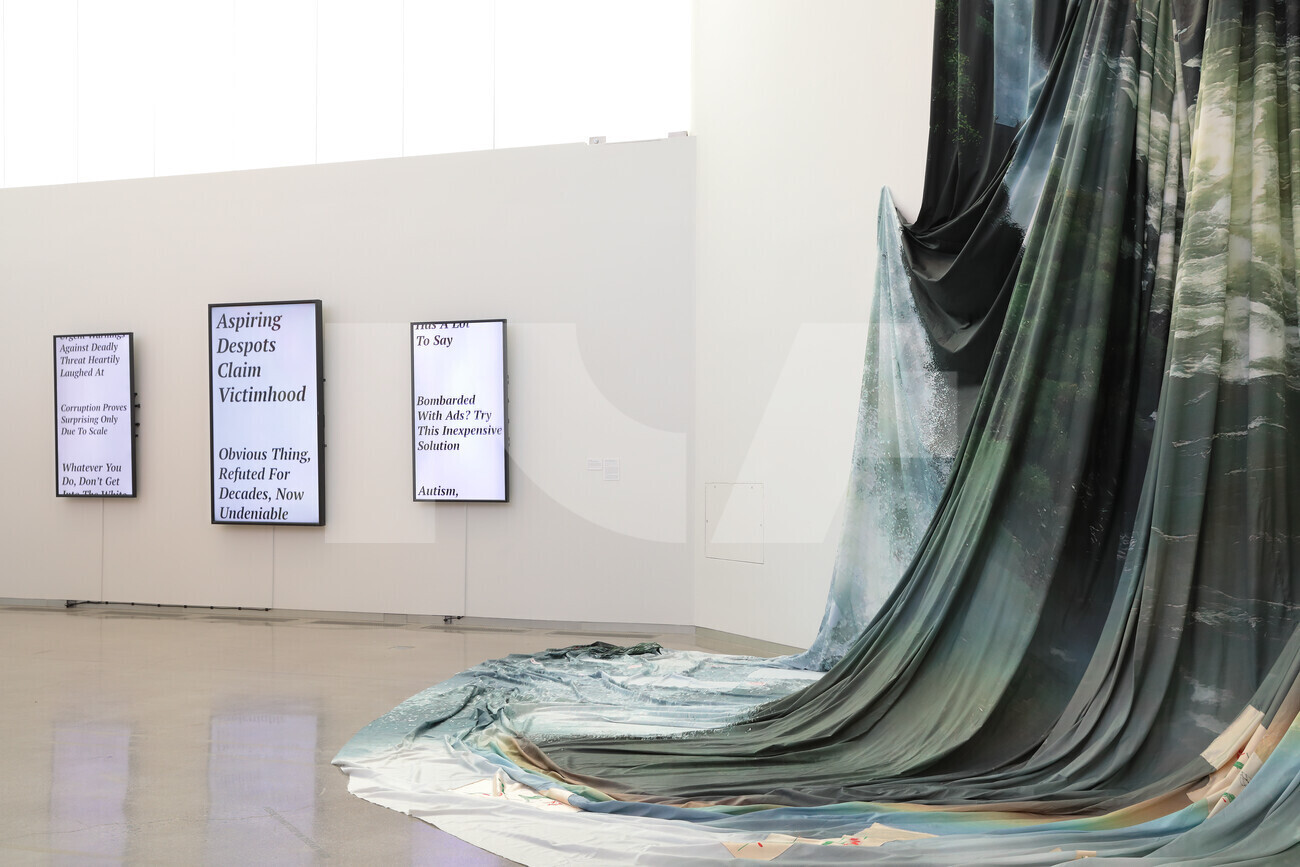installation image of draped fabric and screens with text