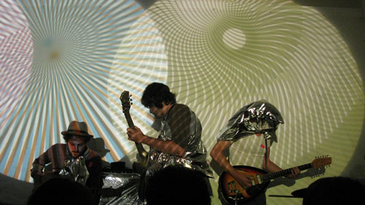 From the performance, Fat Farmer Bob and his Colourful Crazy Beard (Steven L. Anderson, Robby Herbst, and Karl Erickson) with music by The Faraway Places Modal Energy Unit The Baby Boomers Fucked Everything, July 3, 2008, courtesy Steven L. Anderson. 
