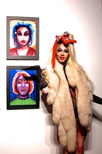 A queen with two needlepoint portraits at the opening of Serving Face. (Photo Sher Pruitt for Project Q Atlanta) 
