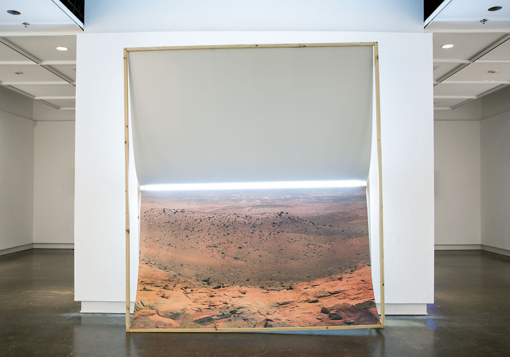Guillermo Gudiño, Infinite Longing,  2013; digital print of NASA image on styrene, wood, fluorescent lamp and rock.