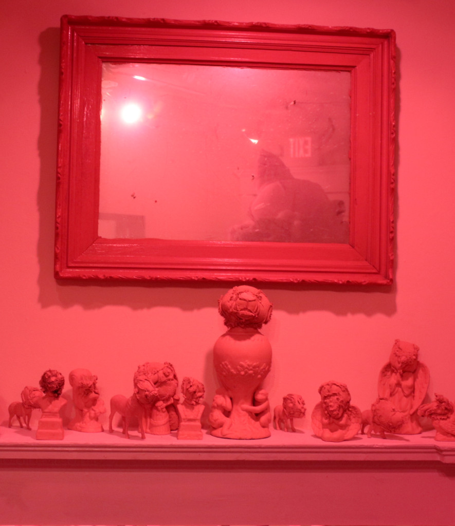 Installation view, with painted mirror, stuffed animal parts, and found objects. 