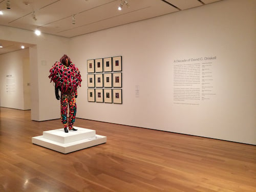 Exhibition view, with a Nick Cave Soundsuit, 2005, and David Driskell's "Doorway" print series, 2008.
