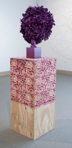Cherished Tchotchke Knows Her Place (violet), 2014; silk flowers, ceramic vase, wood, concrete block, 65 by 15½  by 15½  inches.