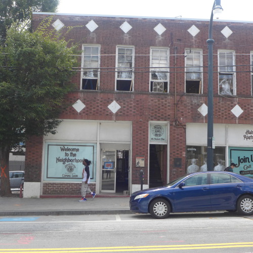The Atlanta Daily World building at 145 Auburn, during renovation, with Borondo's artwork still visible in the windows.