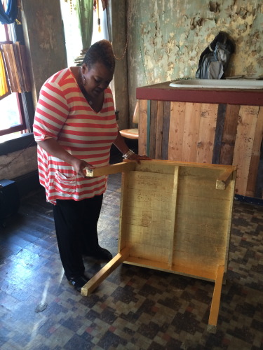 Waddell inspects her piece "Leukerbad" which involved covering a table with gold leaf.