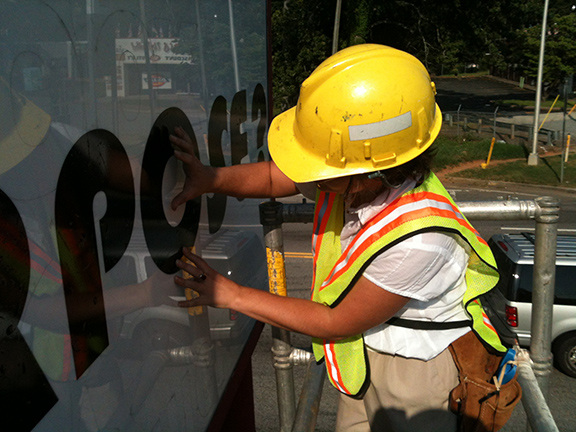 Karen Tauches installing the vinyl letters of What Is Your Soul Purpose? in 2012. 