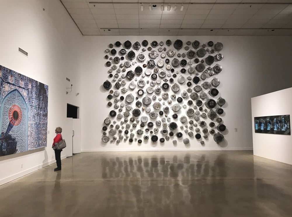 Installation view of "Desert to Delta" at the University of Memphis Art Museum, on view through Jan. 6. On back wall: Food for Thought Almuallaqat 4 , 2016, by Maha Malluh.