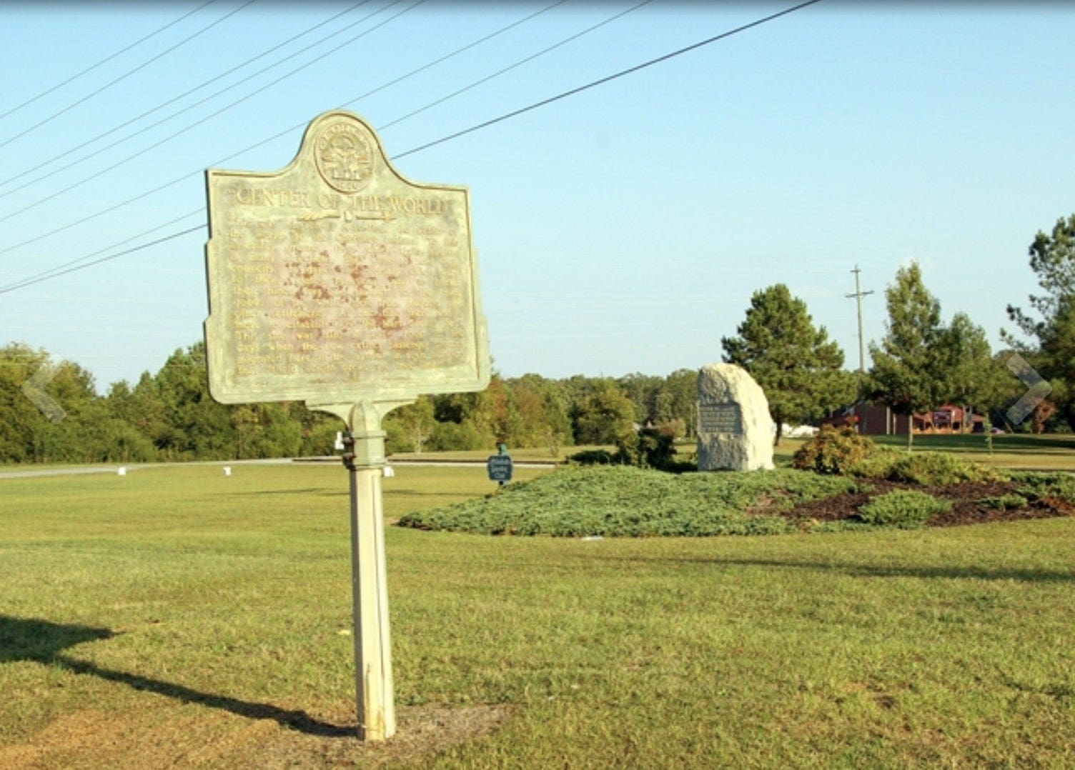 Landscape with an historical marker and a stone monument commemorating the Cherokee "center of the world" site.
