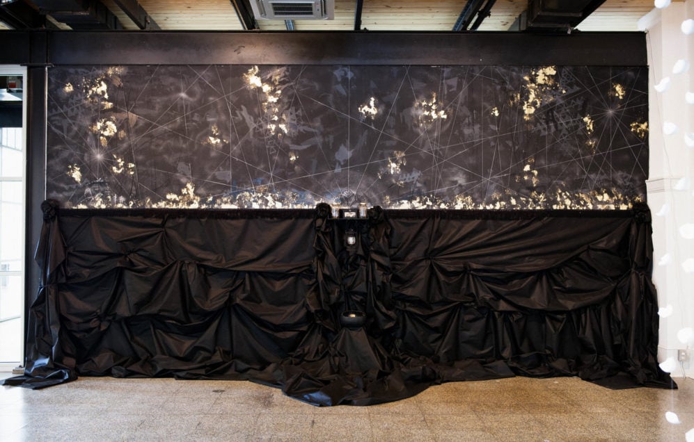 Installation piece by Michi Meko comprising black background with gold leaf and mixed media, part of the exhibition "This is where you'll find me" at the Kress Building in Montgomery