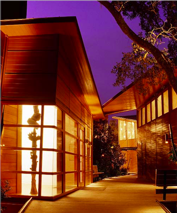 night view of a wooden walkway between three buildings that are illuminated from inside: Atlanta Center for the Arts Call for Artists