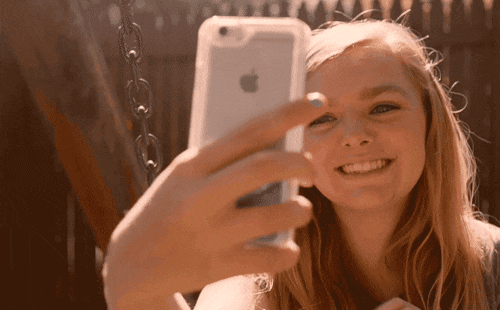 Girl holding phone up to take a selfie.