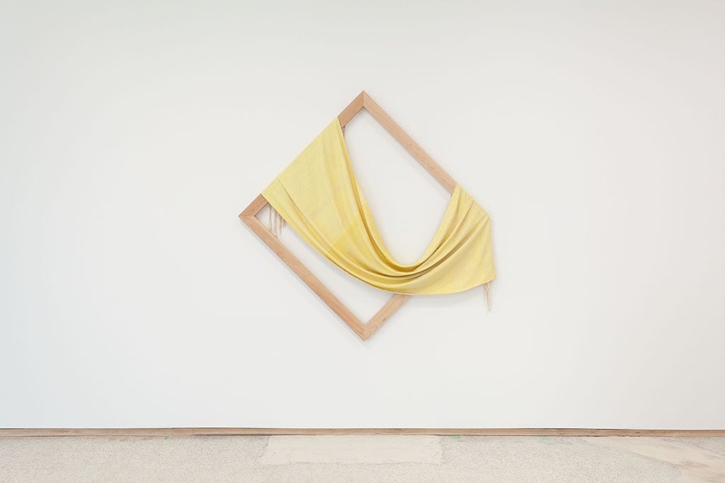 a diamond shaped frame draped with yellow cloth