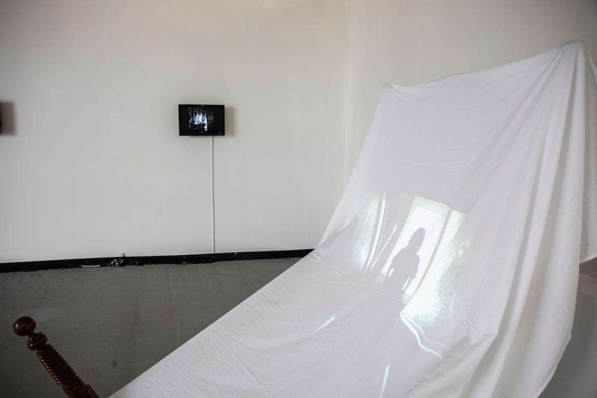 a white sheet with an image of a woman projected on it 