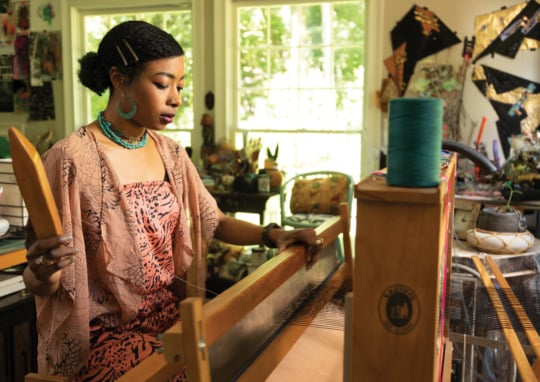 Artist Zipporah Camille Thompson sits at her loom in her Atlanta studio.