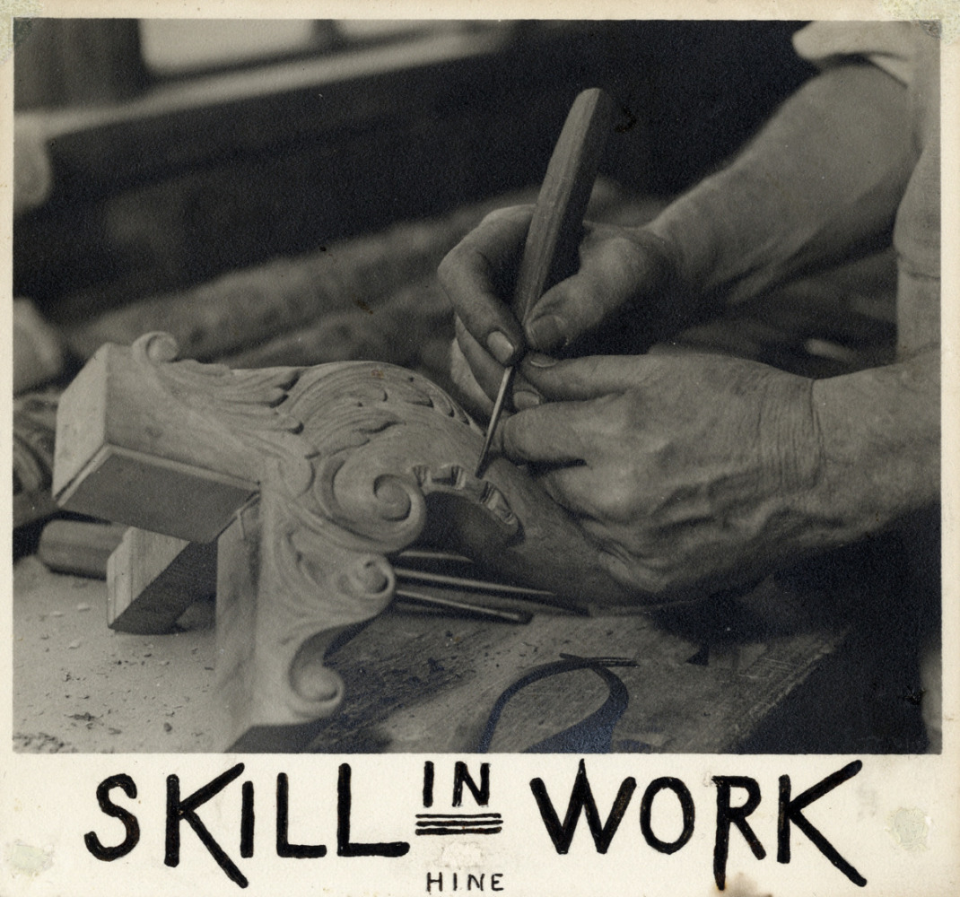 a mans hand holds a chisel, carving detail on a wooden object