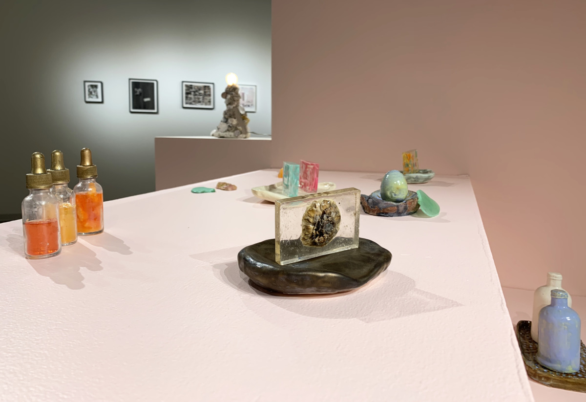 sculptures of glass and ceramic bottles on pink blocks