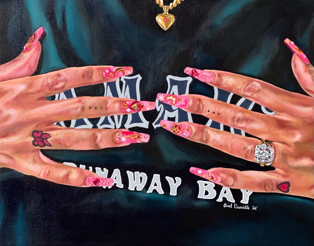 a Black woman's hands feature small tattoos, stacked rings, and a full set of bejeweled hot pink acrylic nails