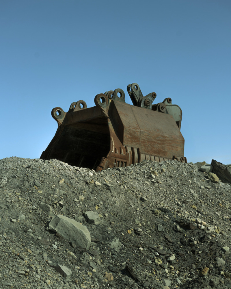 large mechanical object sits on top of a pile of gravel