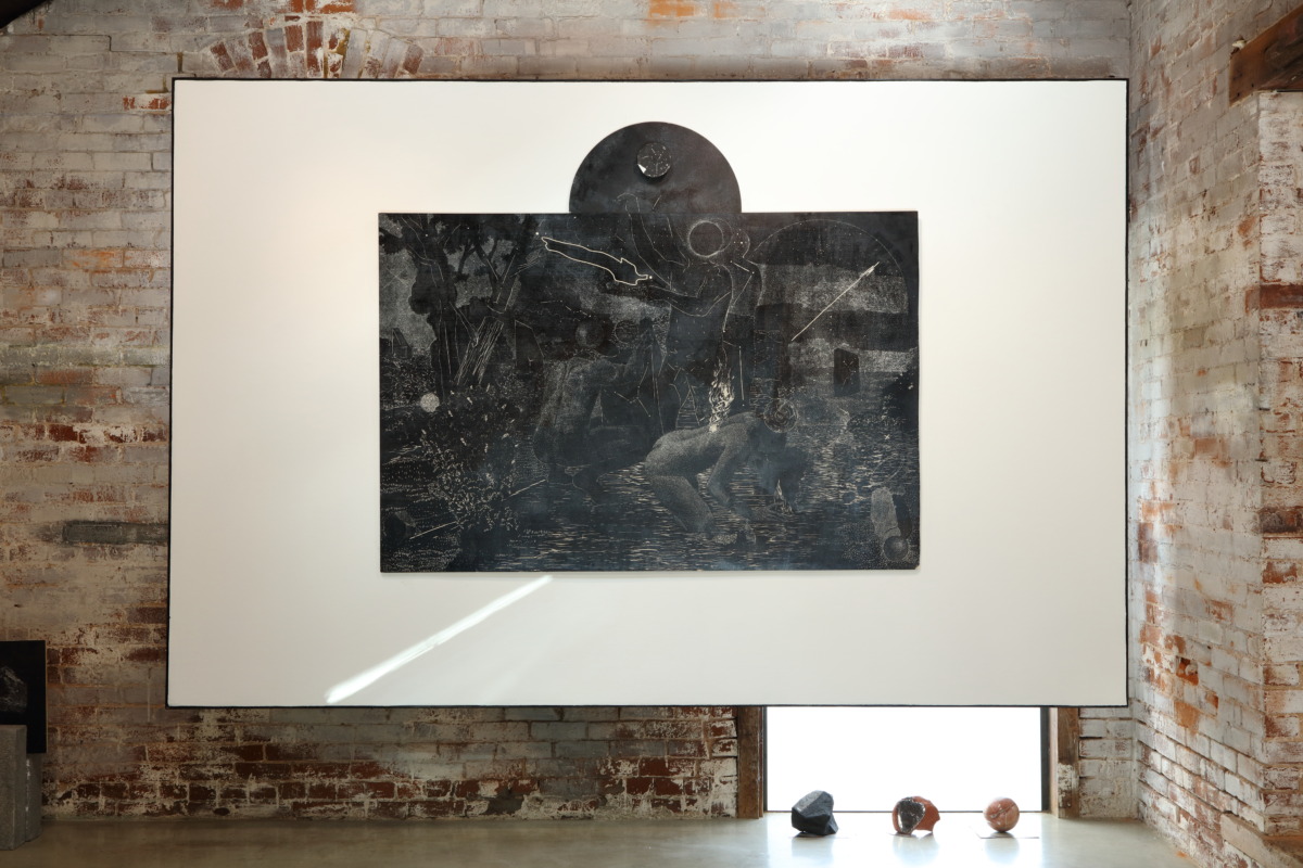 Installation image of white hanging square with black and white etching on top, depicts ambiguous figures in a wilderness scene under the night sky.