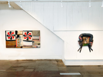 installation view of white wall with two fabric sculptures