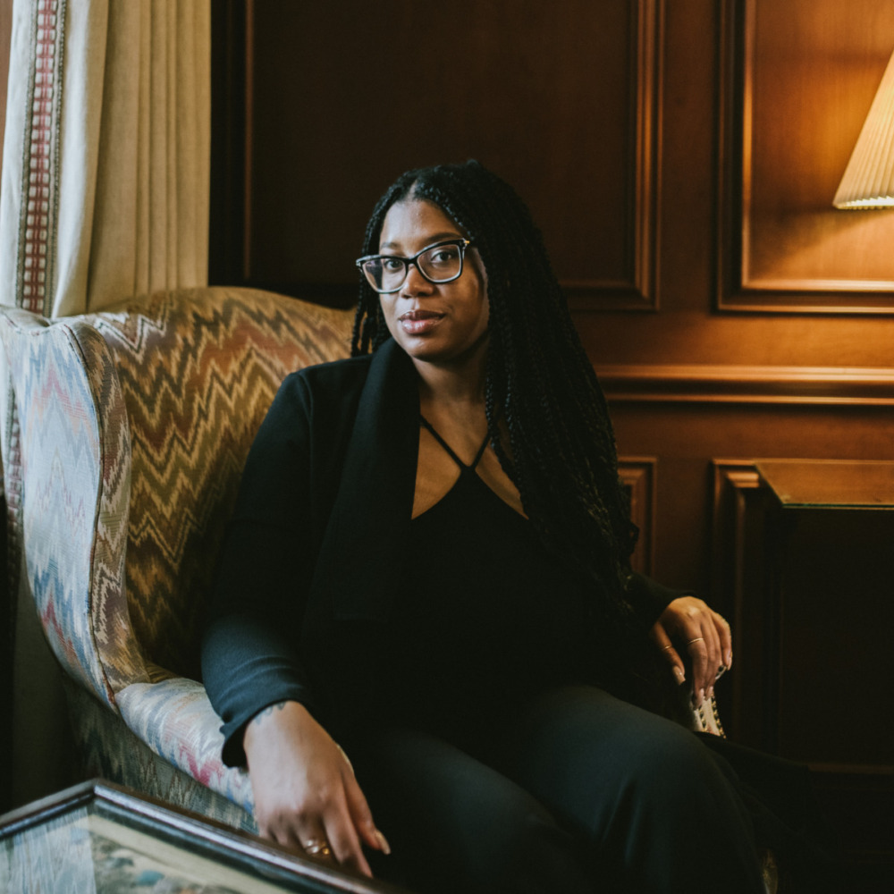 headshot of black woman sitting and posing in an armchair