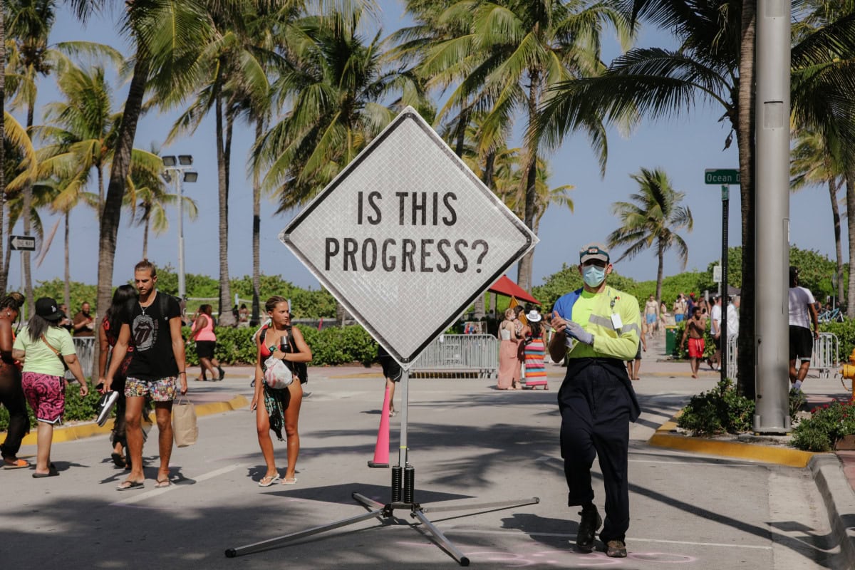 street photography image of sign stating is this progress?