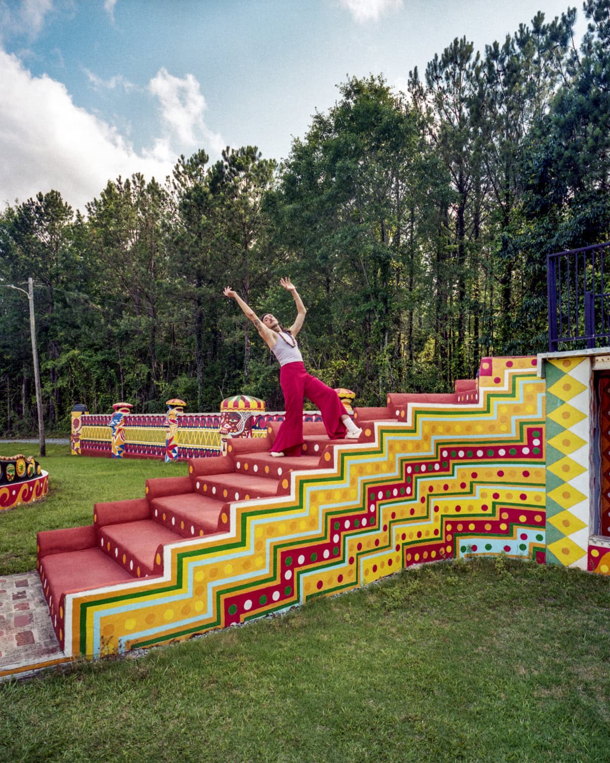 film image of human standing on steps with hands directed towards the sky